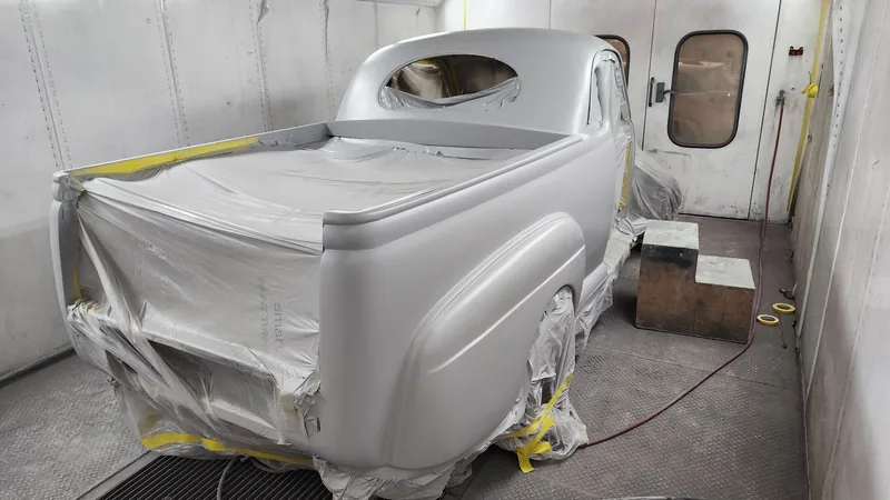 Body and rear tray of the 1946 Ford ute masked up in grey surfacer inside the Kohl Customs spray booth