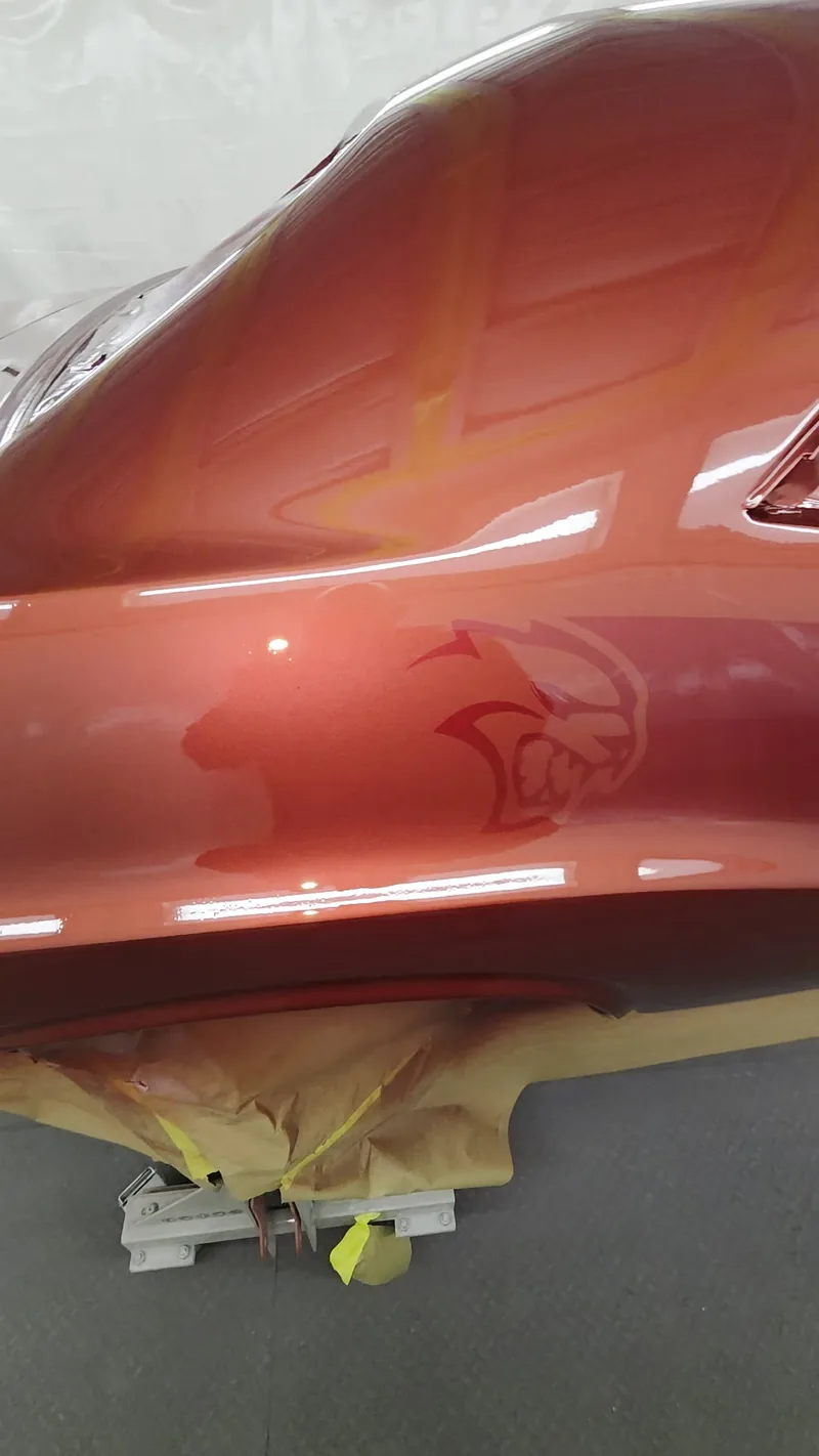 Close-up of the custom metallic red on the 1971 Dodge Challenger, ghosted graphic showing as the light crosses the panel