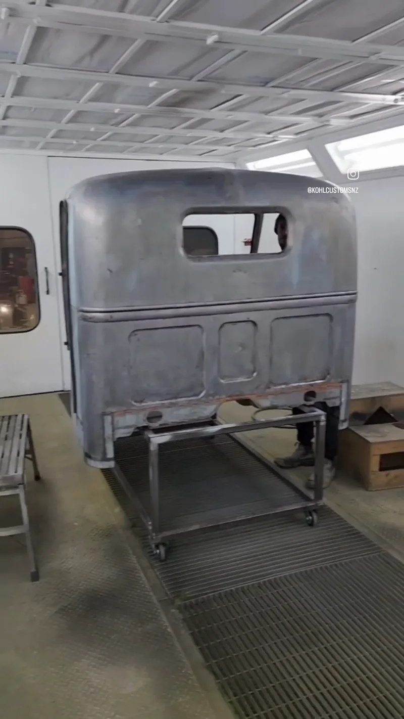 The Bedford cab shell in primer inside the Kohl Customs spray booth