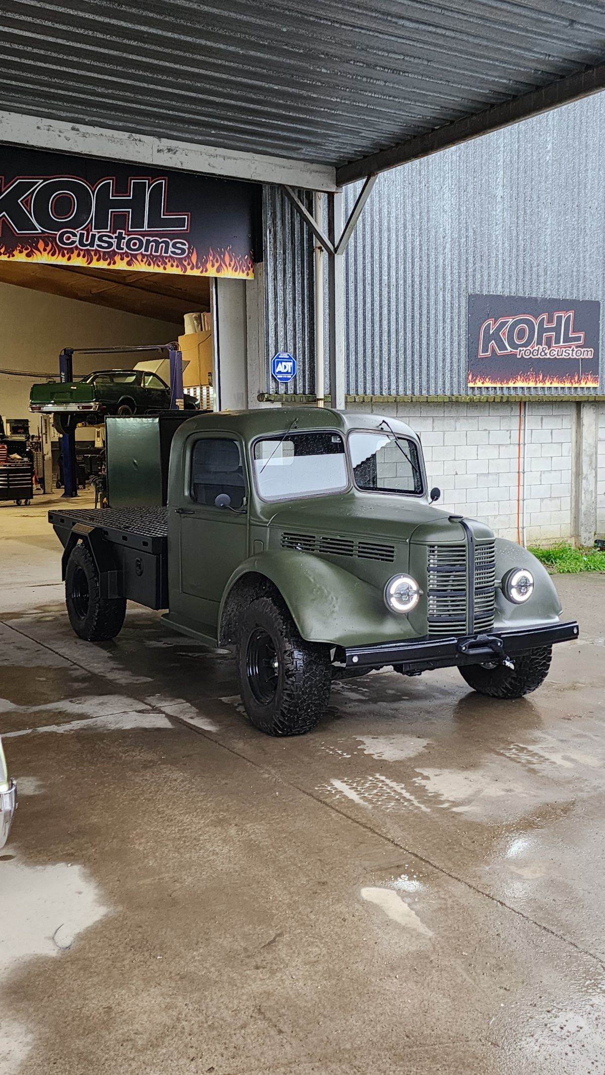 The finished Bedford K cab in army green outside the Kohl Customs workshop at Kuku, on all-terrain tyres