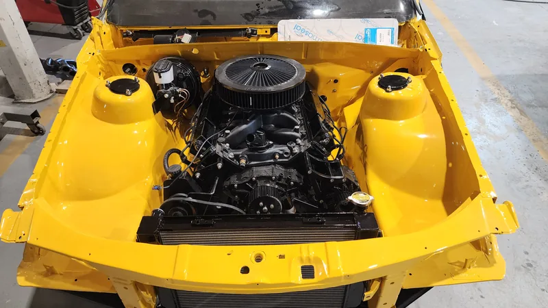 The Holden 304 V8 installed in the painted yellow engine bay of the VN Commodore
