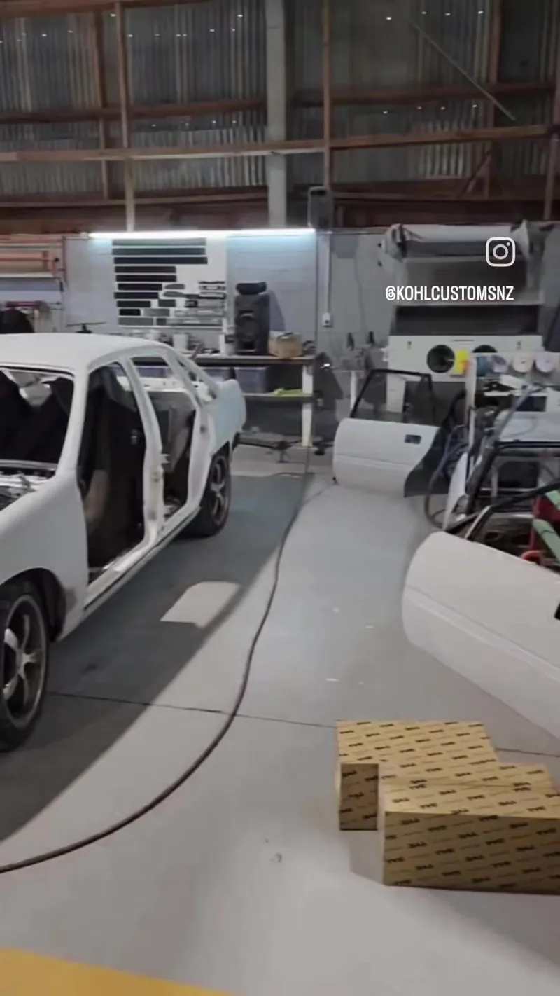 The white VN Commodore stripped of glass and doors inside the Kohl Customs workshop