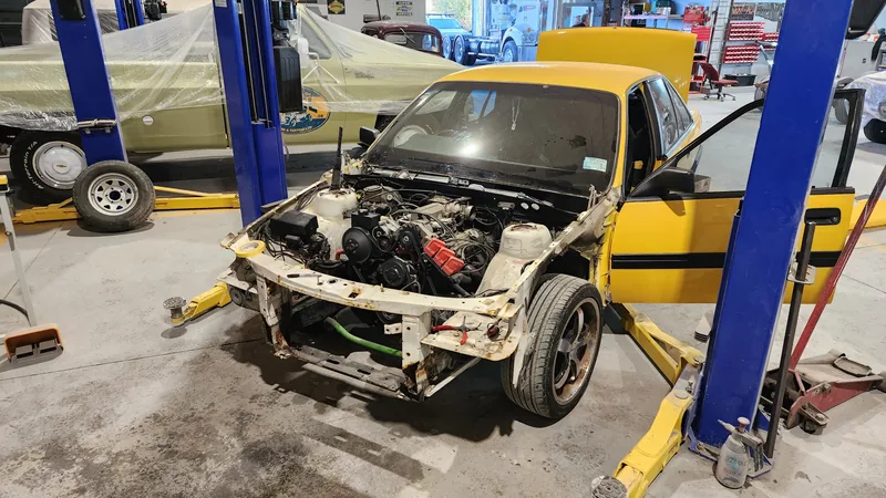 The VN Commodore shell up on the hoist with the engine and front end removed