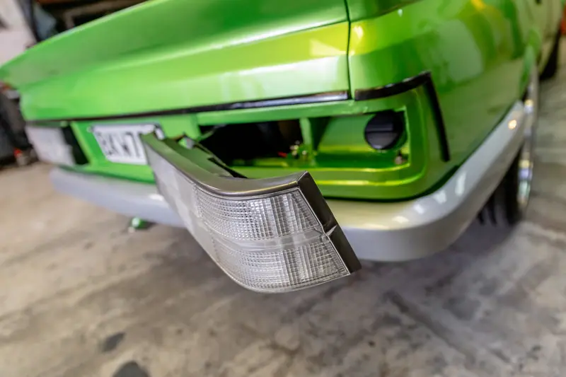 Front corner of the Commodore with the indicator lens removed, showing fresh paint and panel fit during reassembly