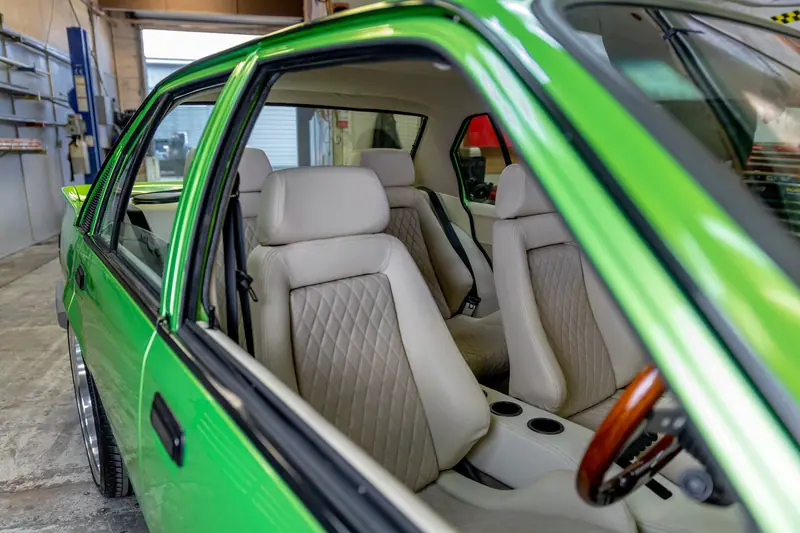 Custom cream diamond-stitch front seats and door card in the restored VH Commodore cabin