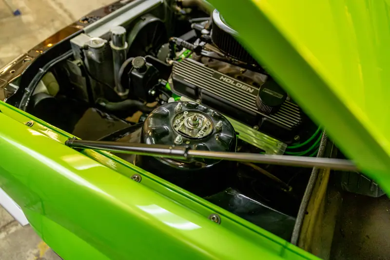Close-up of the Holden V8 rocker cover and chrome air cleaner in the restored VH Commodore engine bay