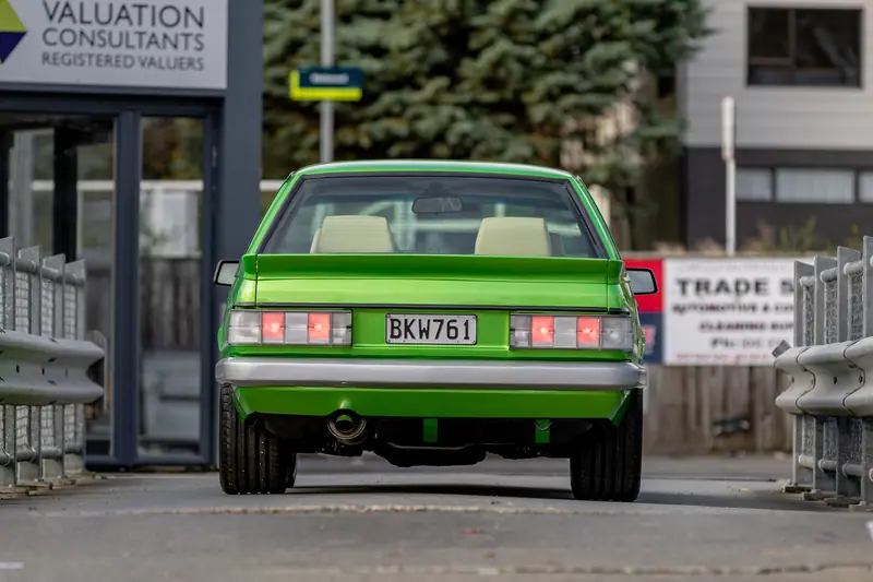 Rear view of the candy green VH Commodore with tail lights lit and a silver rear valance