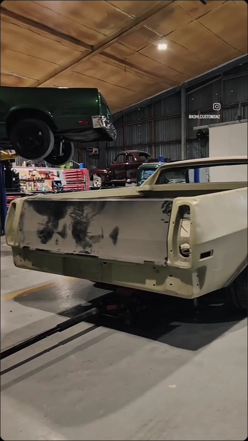 Rear three-quarter view of the stripped HJ Holden ute body in primer at the Kohl Customs workshop