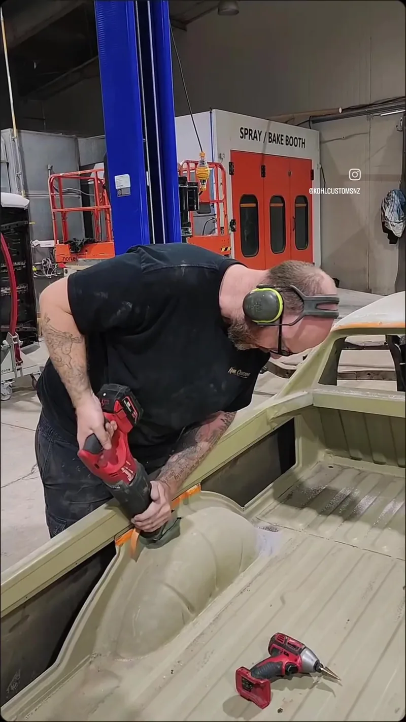 A Kohl Customs fabricator cutting the old floor out of the HJ Holden ute tray with a reciprocating saw